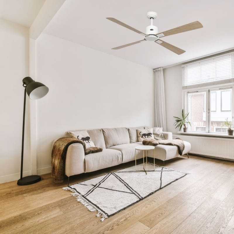 Différence déstratificateur et ventilateur de plafond : comparison d’un plafond blanc avec ventilateur, salon lumineux et canapé; lampe sur pied, tapis clair et grandes fenêtres.
