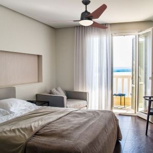 Lit double, salon et balcon avec vue, plafond et rideaux lumineux; idée d’air chaud plafond évoquée par contexte. comment faire descendre l'air chaud du plafond