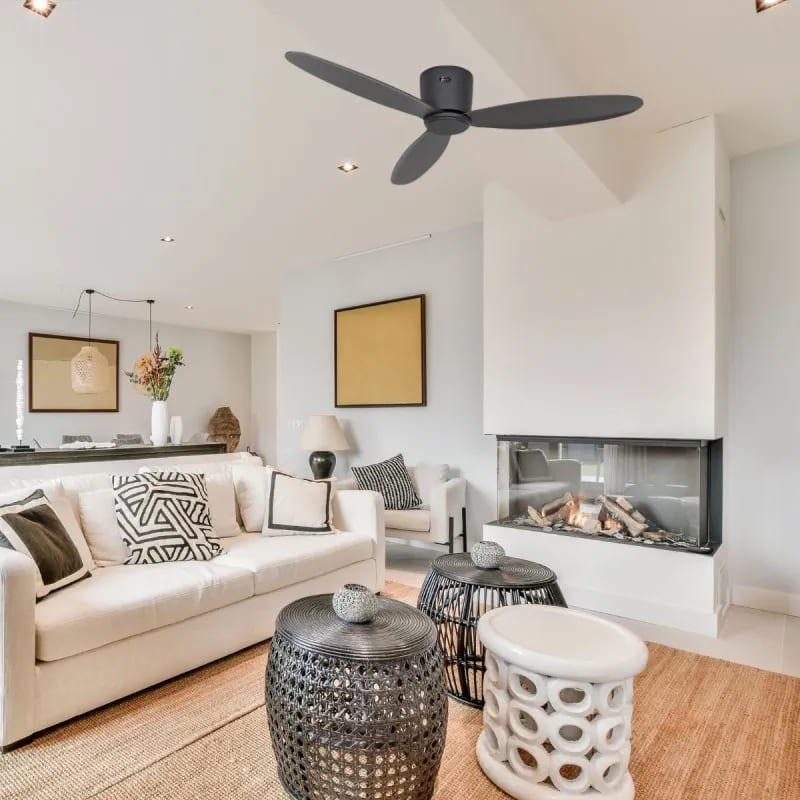 Salon lumineux avec canapé beige et tablettes noir; cheminée moderne et ventilateur au plafond. Déstratificateur pour économie chauffage à démontrer.